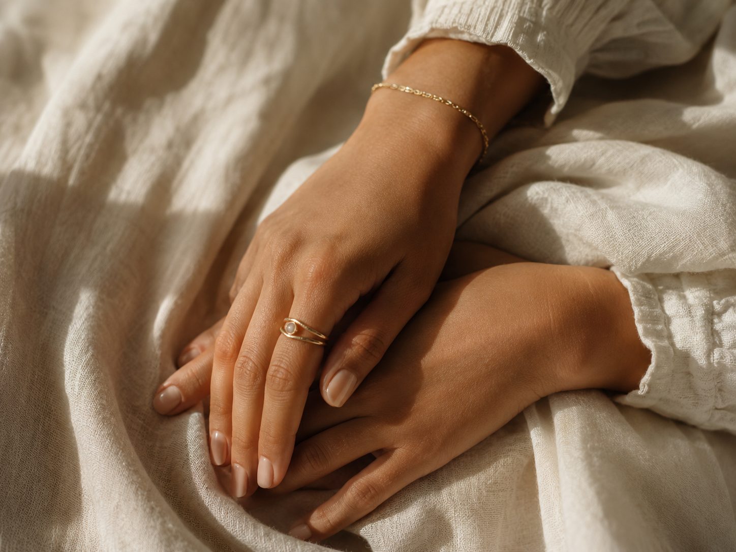 Relaxed hands resting on linen